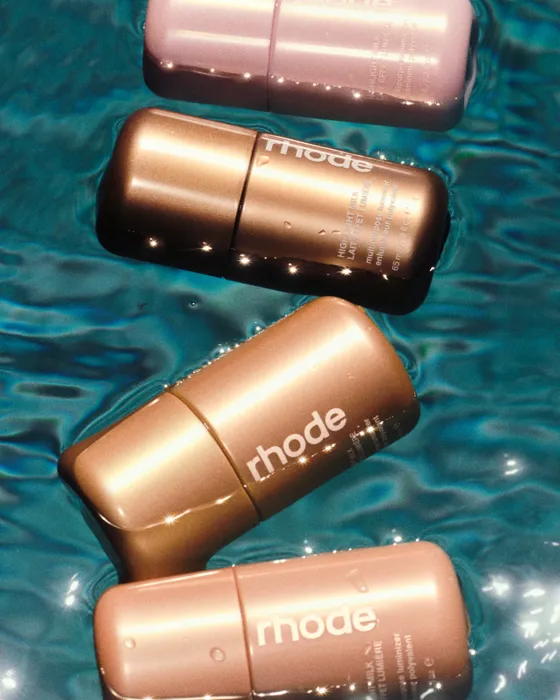 The rhode highlight milk ad creative: four highlight milk sticks photographed in sunlit water.